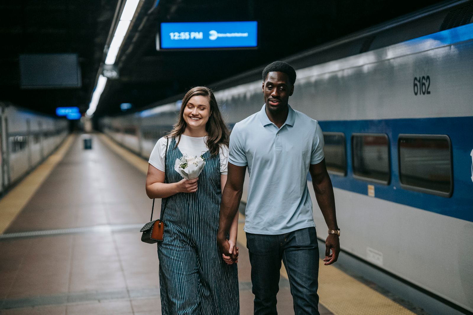 Couple holding hands on a station platform, symbolising cross-border couples who meet between France, Belgium, Germany and Luxembourg
