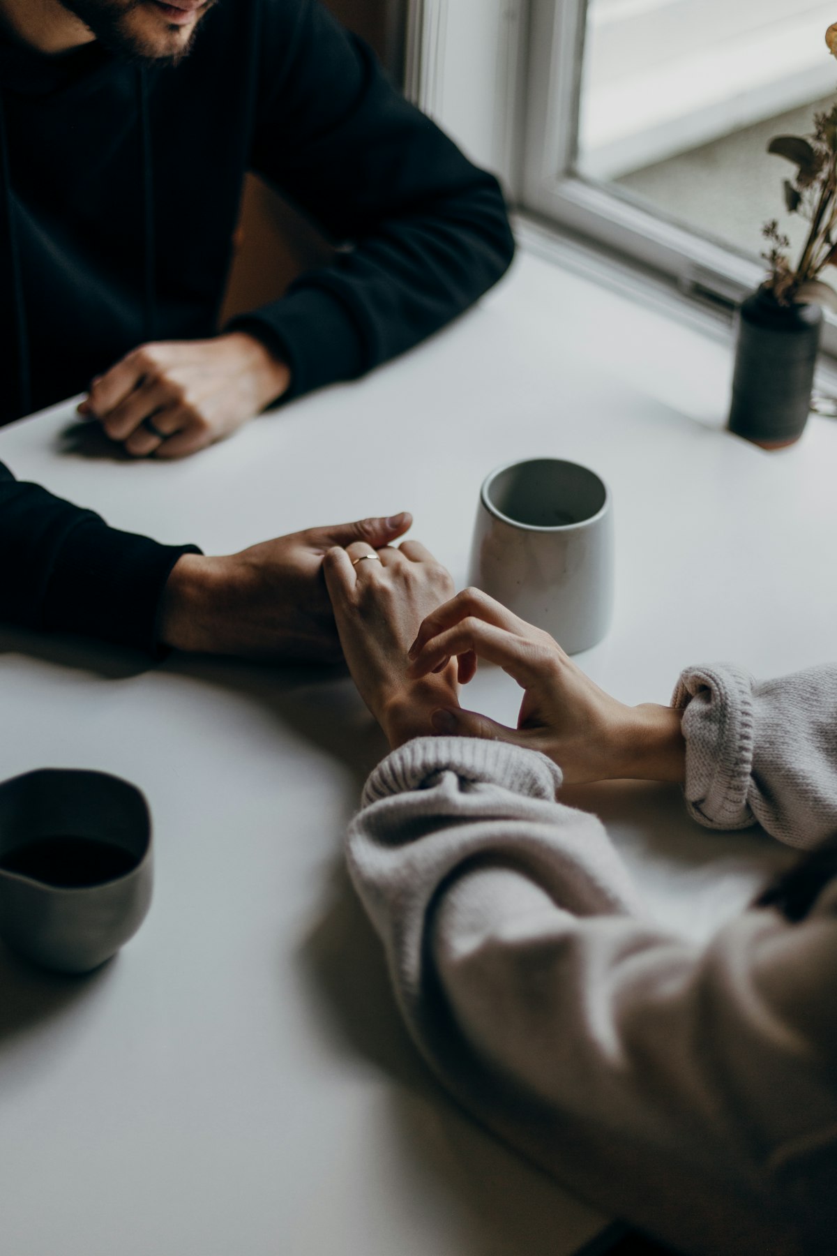 Two hands resting on one another around a cup, no faces — meeting someone after widowhood in Luxembourg