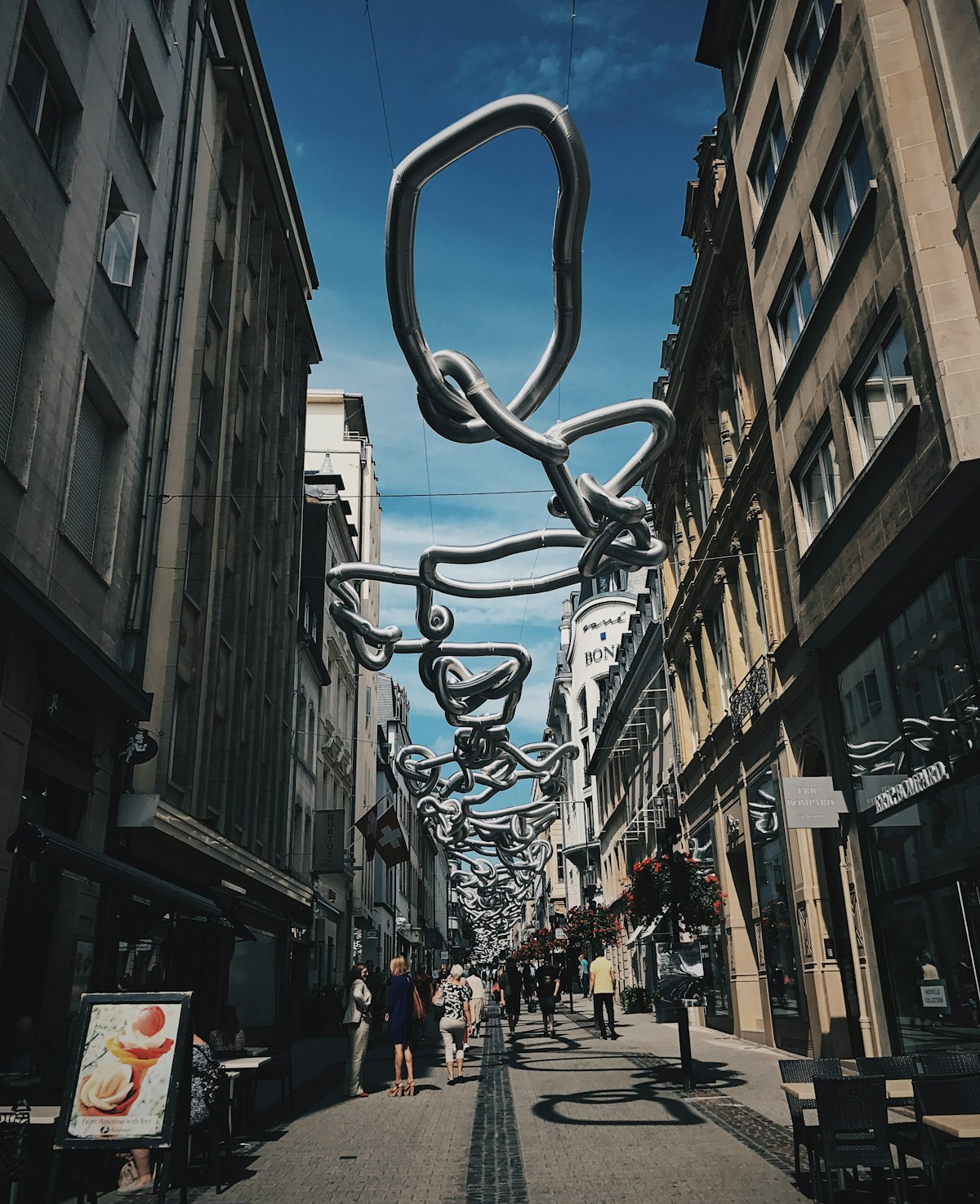 Pedestrian street in central Luxembourg City under a hanging sculpture — new in Luxembourg, social circle and dating